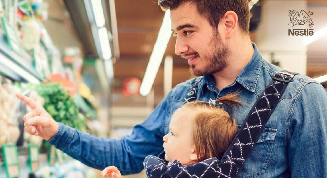 Mann mit Baby beim Einkaufen