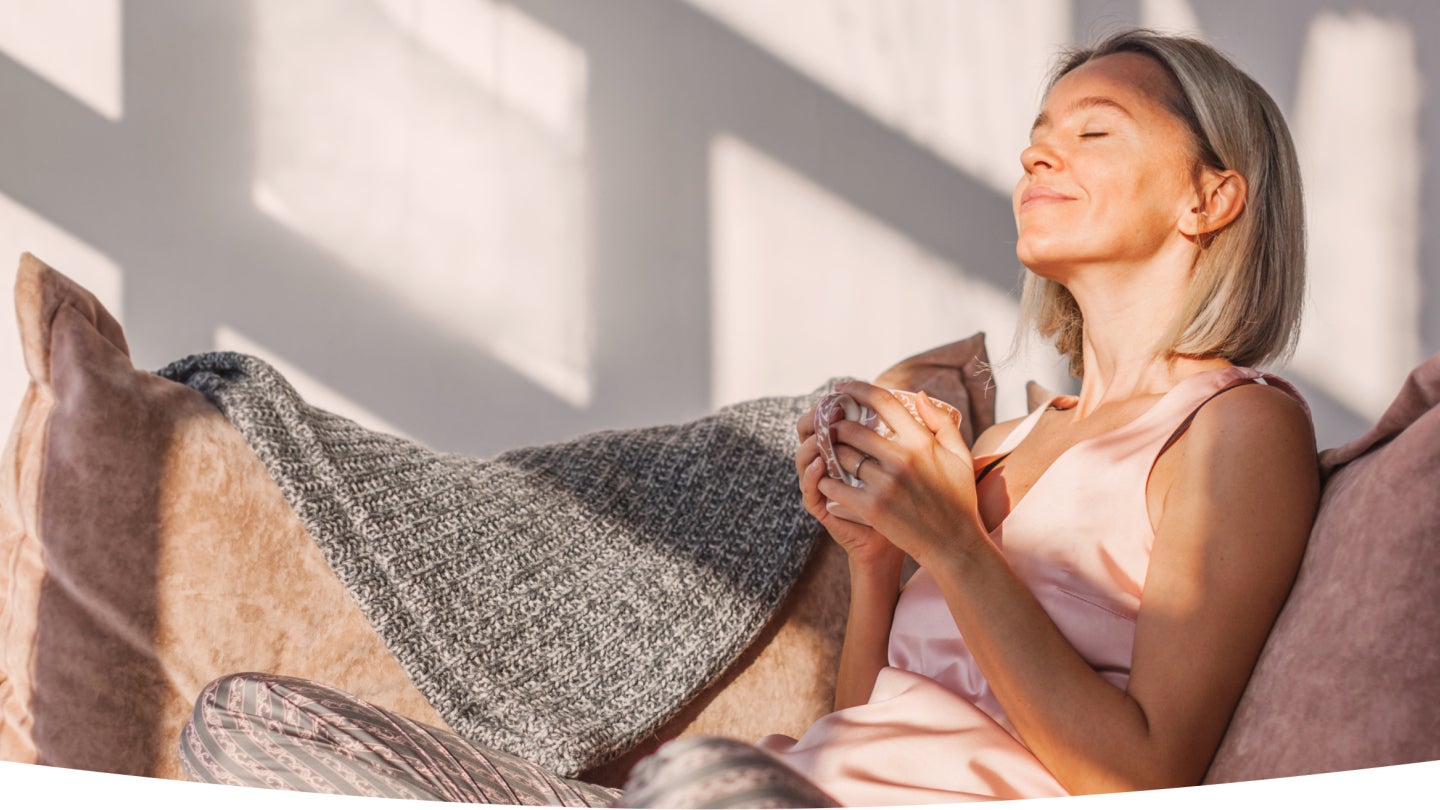 Frau genießt Kaffee auf der Couch