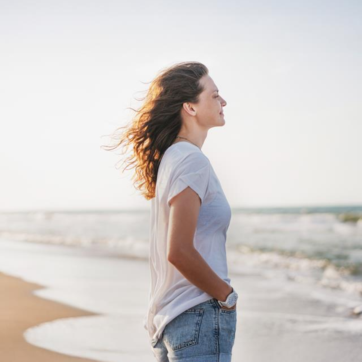 Frau, die am Strand steht